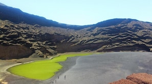 A volcanic landscape with green lakes and rugged terrain.