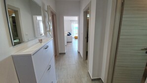 A hallway with a white dresser, a mirror, and a door leading to another room. - Beach front apartment for family vacation in Mandre (Mandre)
