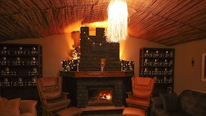 A cozy living room with a fireplace, wooden ceiling, and bookshelves. - Alex Village Life (Kartepe)
