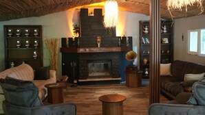 A cozy living room with a fireplace, wooden furniture, and a bookshelf. - Alex Village Life (Kartepe)