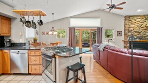 A spacious kitchen with a central island, wooden cabinets, and hanging pots. - Cutty Sark Court #1 3br 2.5ba Mountain Views 3 Bedroom Townhouse by RedAwning (Silverthorne)
