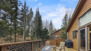 A wooden deck with outdoor furniture, including a table and chairs, and a grill. - Cutty Sark Court #2 3br 2.5ba Mountain Views 3 Bedroom Townhouse by RedAwning (Silverthorne)