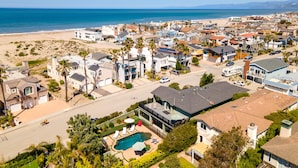 Zona residencial costera con casas, playa y piscina.