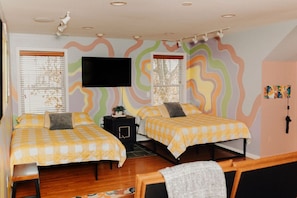 A bedroom with two beds, a TV, a heater, and a window with blinds. - Waterfront studio w/ pool - shopping and beaches (Lincoln)