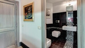 Um banheiro com piso xadrez preto e branco, pia branca e vaso sanitário.