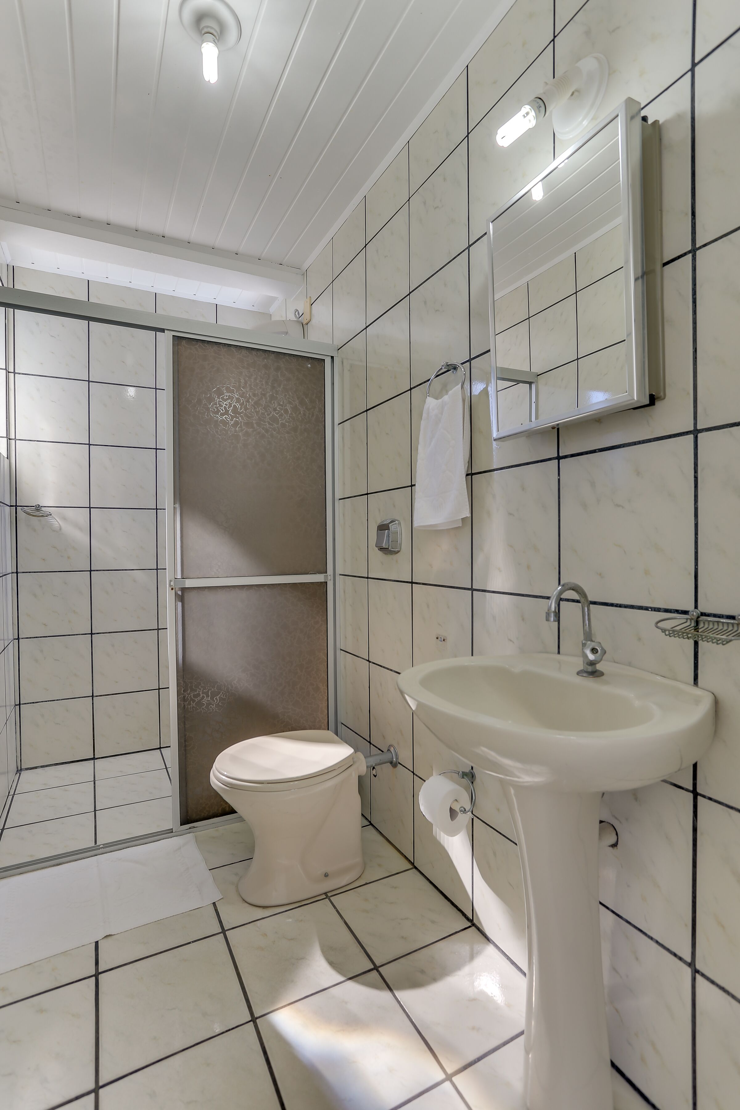 A bathroom with a toilet, sink, and shower.