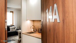 A modern kitchen with a wooden door labeled "14A" and a sink. - BatogoSpot Tumski (Wroclaw)