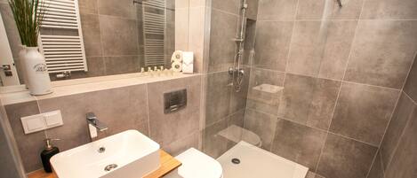 A modern bathroom with a large bathtub, a separate shower area, and a toilet.