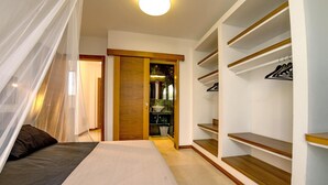 A bedroom with a bed, a walk-in closet with shelves, and a bathroom with a sink and mirror. - Casa Yuna with heated pool in El Roque (El Roque)