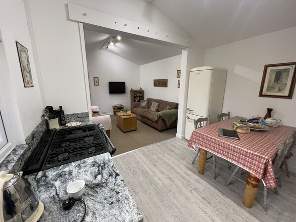 A compact living space with a kitchen, dining area, and a living room.