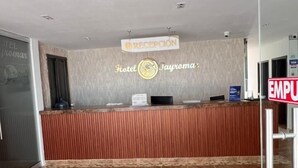 A hotel reception area with a reception desk, a sign for 'Hotel S Jayroma', and an 'EMPU' sign. - Hotel Tayromar (Santa Marta)