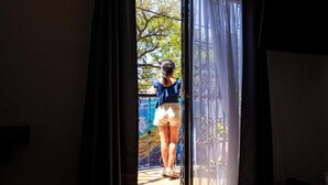 A person standing at a doorway with a view of an outdoor area. - Hotel Tayromar (Santa Marta)
