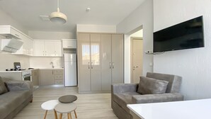 A modern apartment with a kitchen, dining area, and living room. - Azize Palas Apart (Cesme)