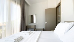 A hotel room with a neatly made bed, a bedside table, a mirror, and a wardrobe. - Azize Palas Apart (Cesme)