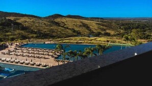 A resort with a pool area, lounge chairs, and a view of the surrounding landscape. - Tauá Resort & Convention Alexânia (Alexania)
