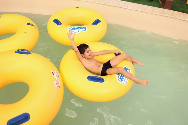 A child floating on a yellow inflatable ring in a pool.