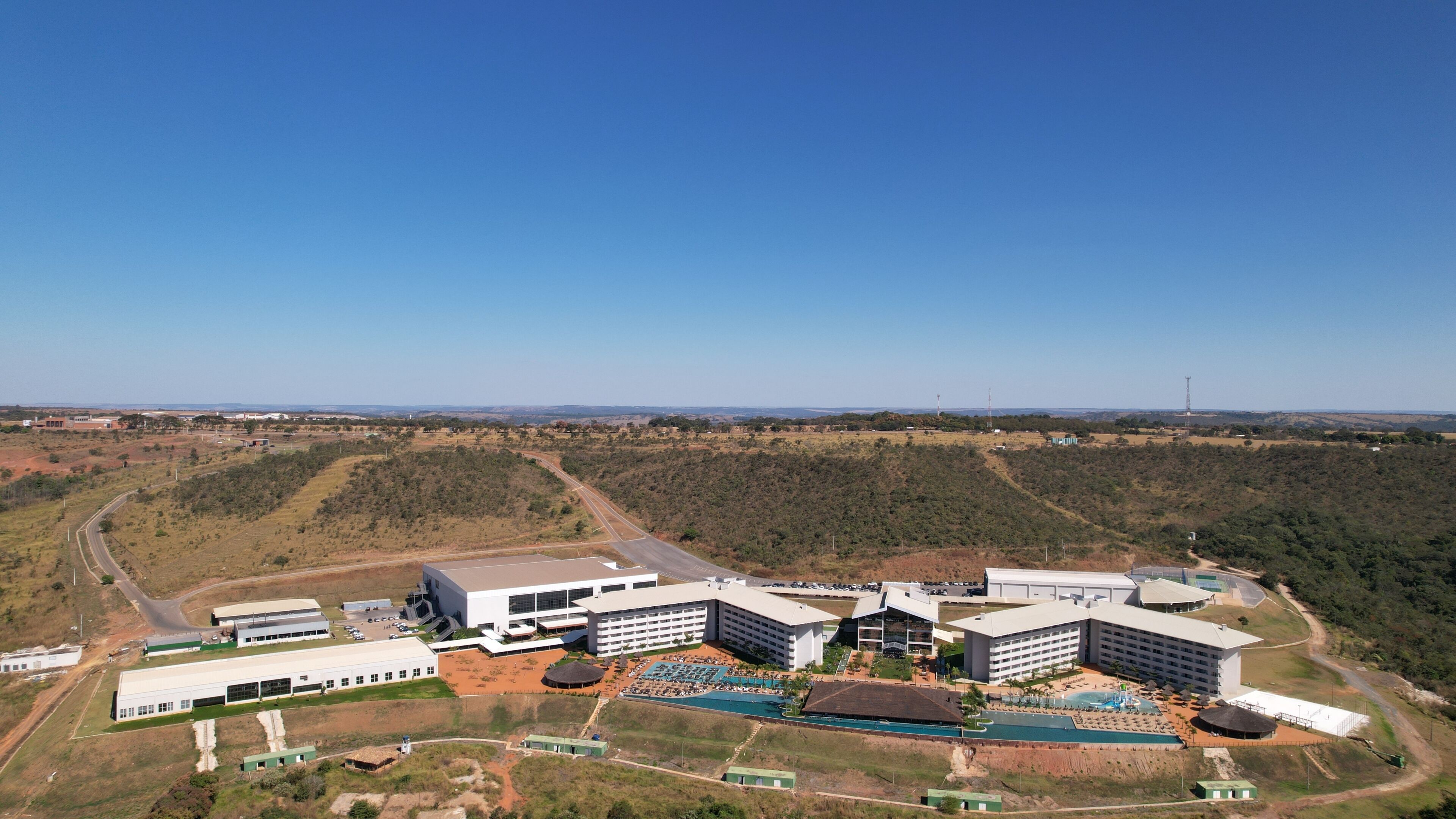 A large hotel complex with multiple buildings, a swimming pool, and a landscaped area.