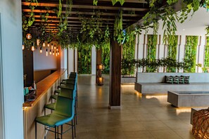 Ein modernes Interieur mit Bar, Sitzgelegenheiten und Grünpflanzen.