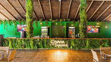 Zona de bar con pared verde, techo de madera y asientos.