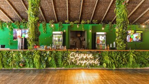 A bar area with a green wall, wooden ceiling, and hanging plants. - Tauá Resort & Convention Alexânia (Alexania)