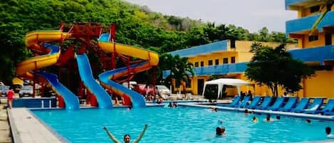 Una piscina al aire libre, camas de piscina gratis, sombrillas