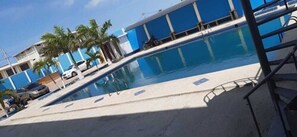 A swimming pool with a clear blue water surface, surrounded by a concrete deck and palm trees. - Grand Hotel Paraiso Salinas (Salinas)