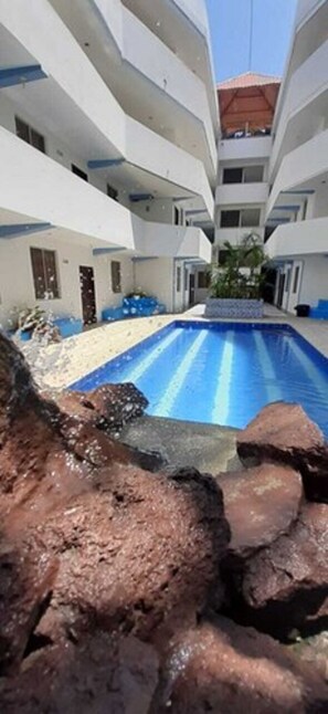A modern building with a central swimming pool surrounded by rocky terrain. - Grand Hotel Paraiso Salinas (Salinas)