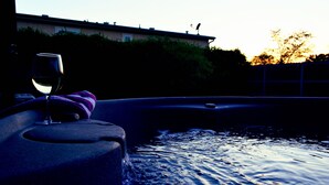 A hot tub with a glass of wine and a towel, surrounded by water. - Casa Acero - hot tub spa, comfortable, views, private (Alpine)