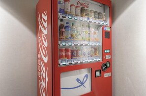 Enjoy a variety of beverages from this vending machine, offering Coca-Cola, Aquafina water, and other soft drinks.