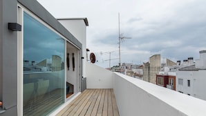 A balcony with a view of the cityscape, a glass door, and a satellite dish. - Olá Lisboa Apartment (Lisboa)