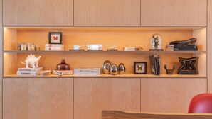 A wooden shelf with decorative items, books, and a small red chair. - Olá Lisboa Apartment (Lisboa)