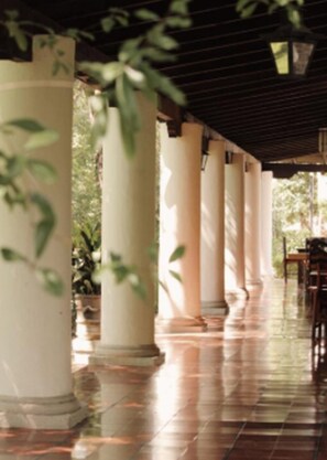 A covered outdoor area with columns and a tiled floor, likely part of a hotel or public building. - Hotel Rancho El Morillo (Saltillo)