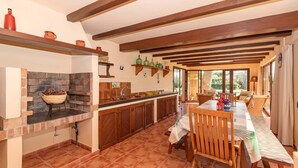 A spacious kitchen with a large island, wooden beams, and a view to the dining area. - 3 bedroom villa, with private pool and BBQ, Pollensa (Pollensa)