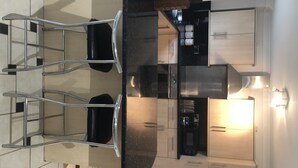 Uma cozinha moderna com ilha central, eletrodomésticos de aço inoxidável e um espaço para bar.