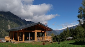 A wooden cabin with a balcony, surrounded by mountains and a clear sky. - Modern Chalet With Garden Chamonix (Chamonix-Mont-Blanc)