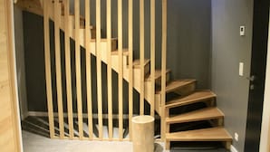 A wooden staircase with a modern design, leading to a dark-colored room. - Modern Chalet With Garden Chamonix (Chamonix-Mont-Blanc)