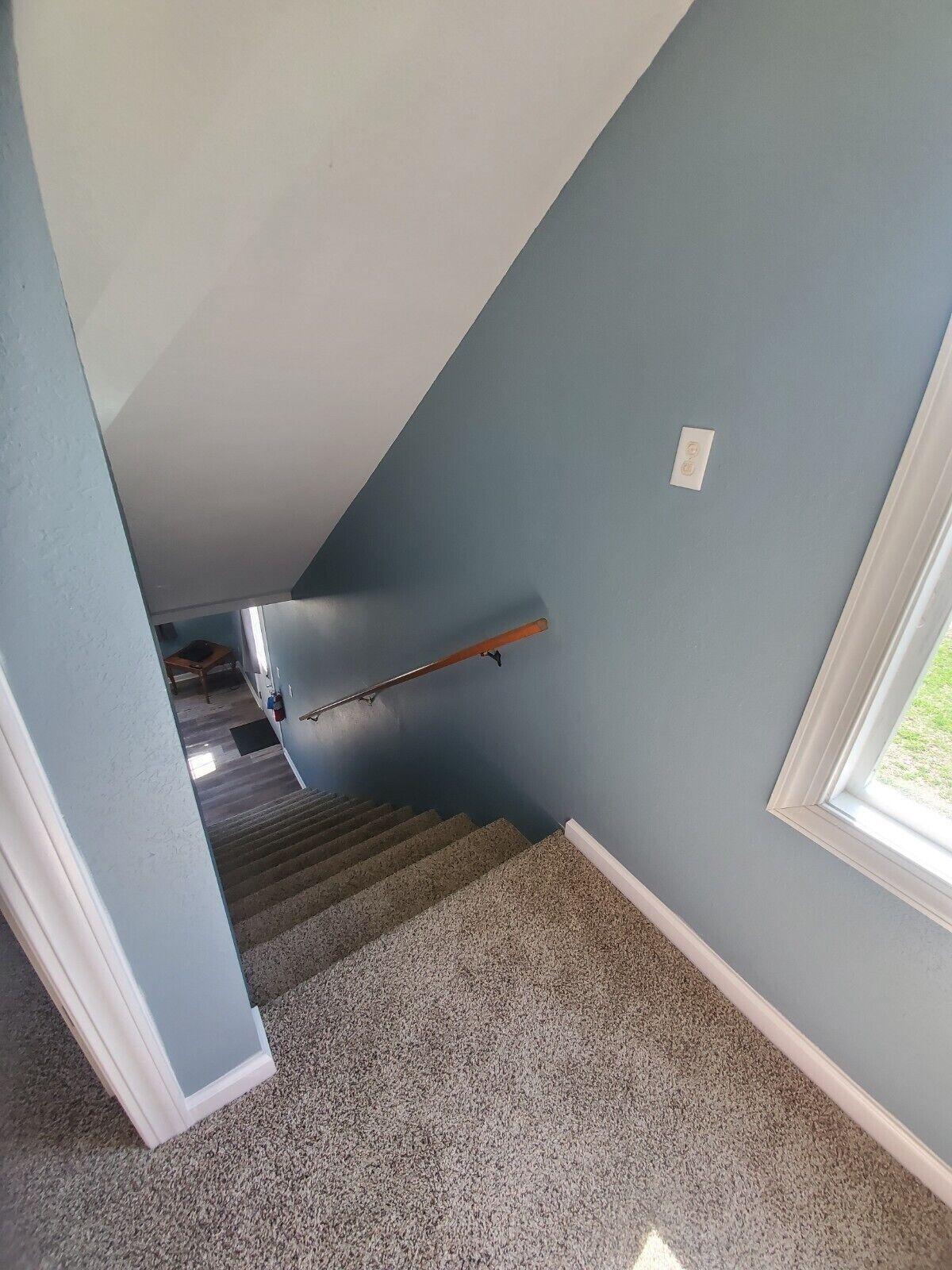 A staircase with carpeted steps leading to a landing.