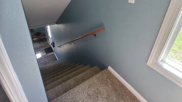 A staircase with carpeted steps leading to a landing.