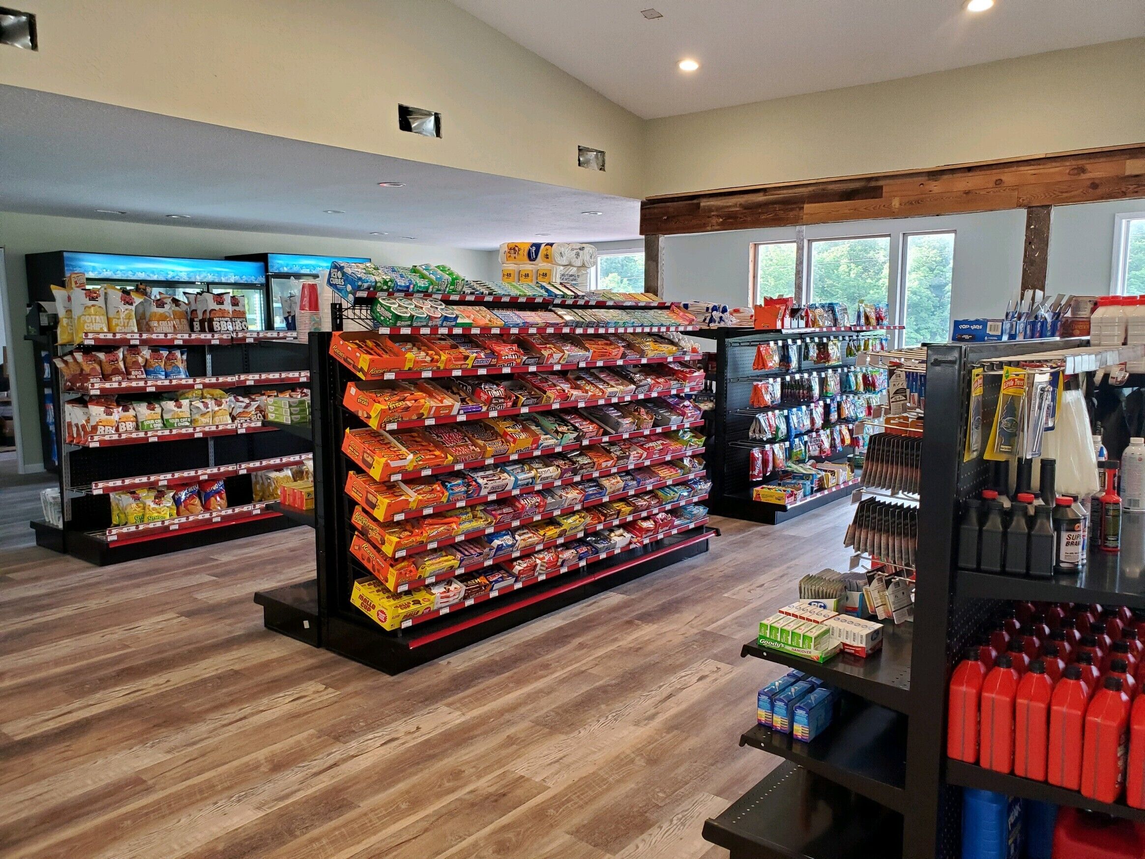 Interior de una tienda de comestibles con estantes llenos de productos y bebidas.