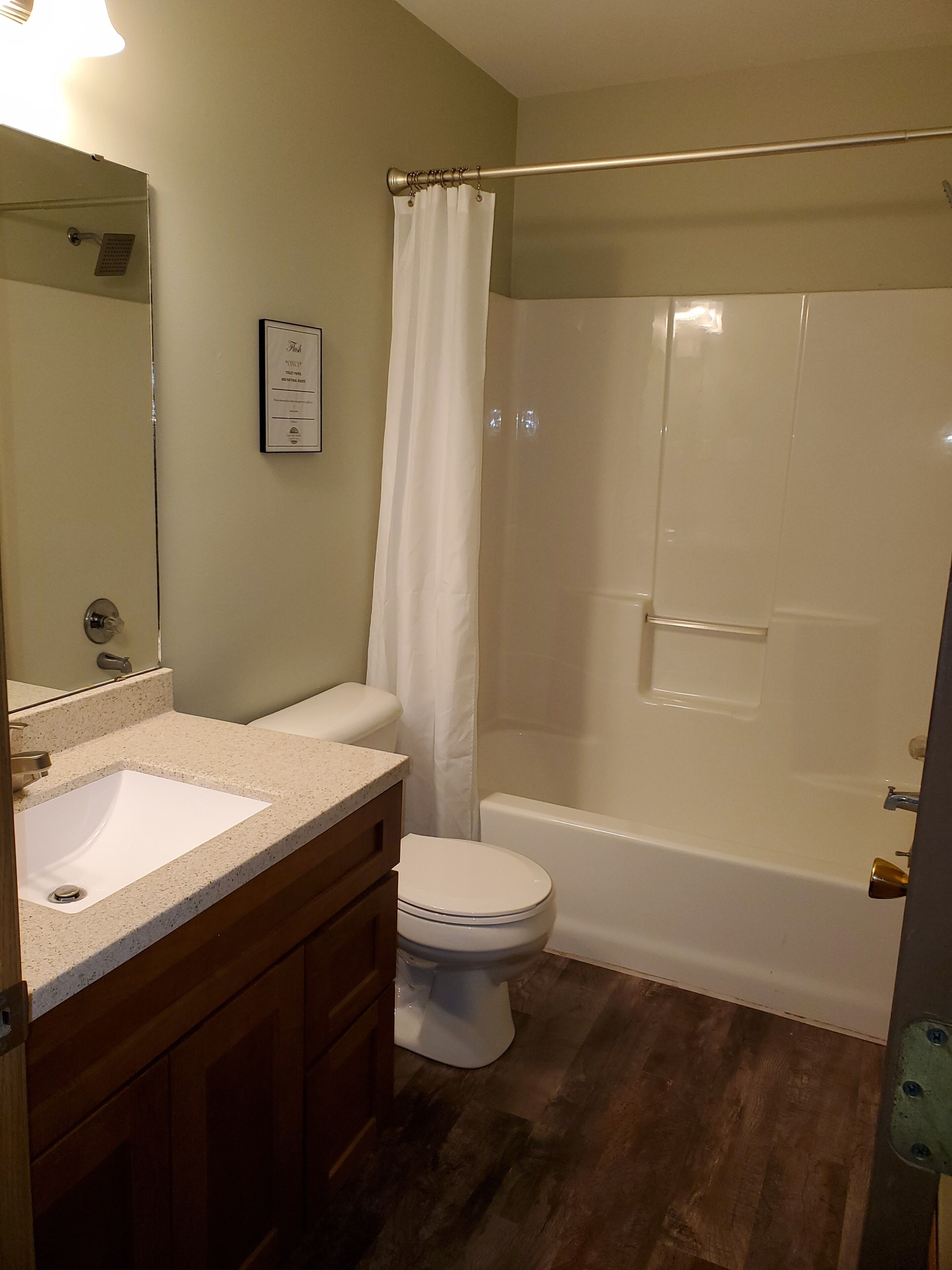 Une salle de bain avec un lavabo, des toilettes et une douche.