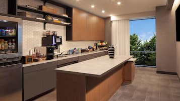 Une cuisine moderne dotée d’un îlot central, d’appareils électroménagers intégrés et d’une grande fenêtre donnant sur un paysage verdoyant.