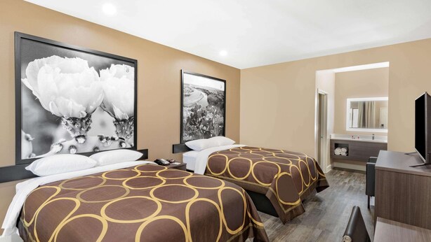 A hotel room with two beds, a large window, a desk, and a bathroom visible through an open door. - Super 8 by Wyndham Houston NW Beltway 8/West Rd (Houston)
