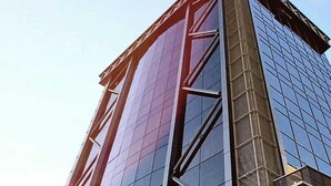 A modern building with a glass facade and a prominent red structural element. - Le Luxe suites hotel & SPA (Bursa)