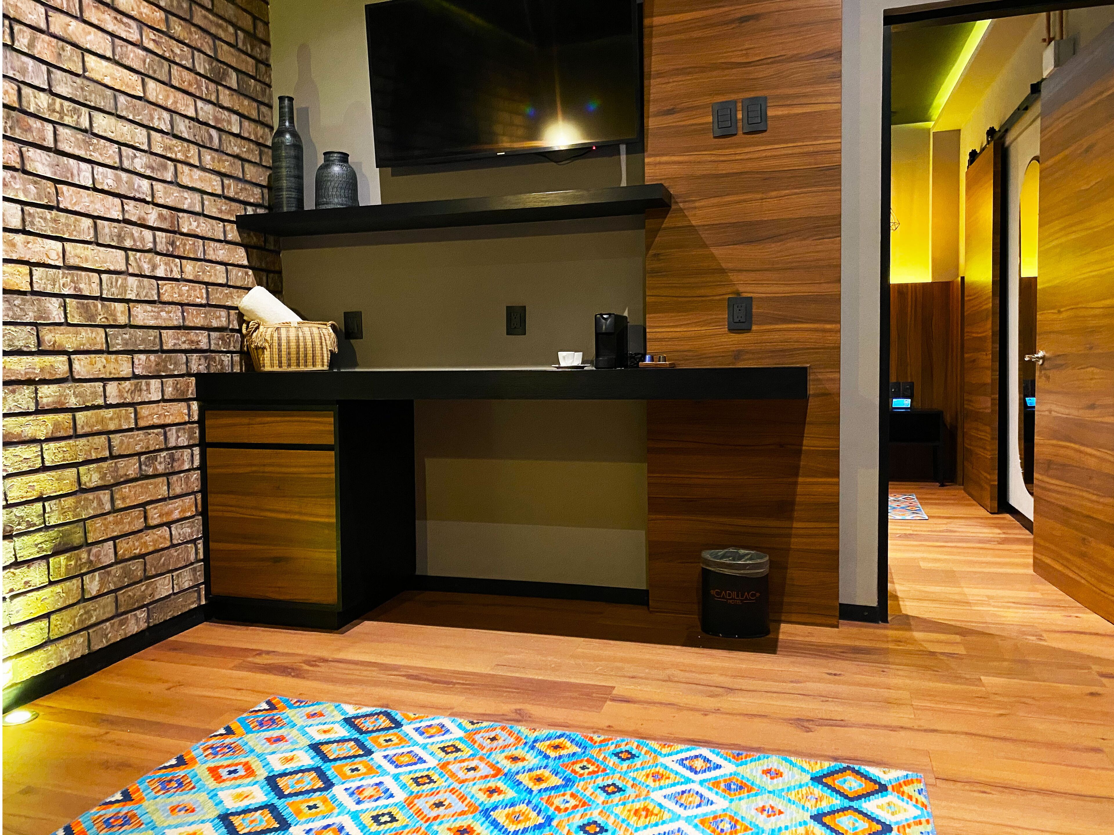 A modern kitchen with a brick wall, wooden cabinets, and a countertop.