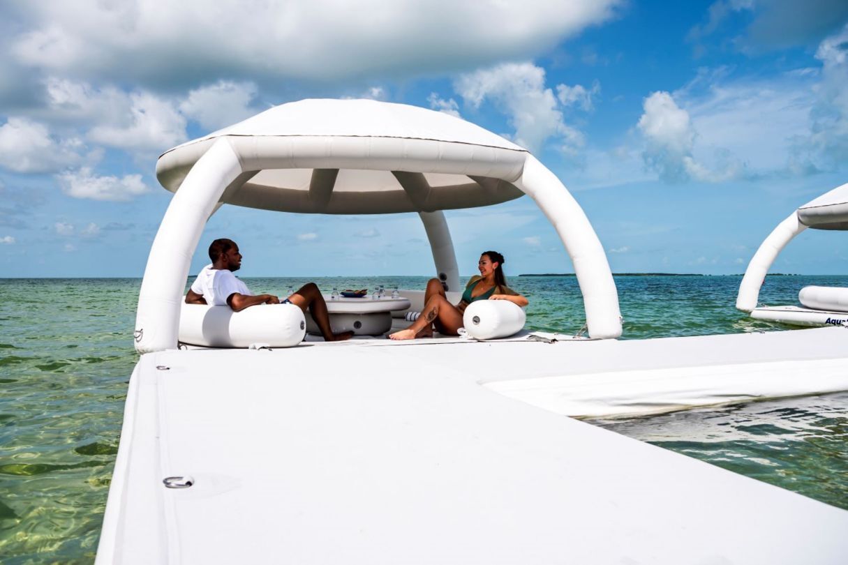 A boat with a covered seating area and a table, surrounded by clear water.