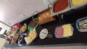 A buffet with various food items including bread, pastries, and meats. - Hotel Araguaia (Canaa dos Carajas)