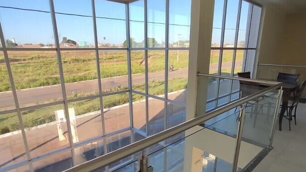 A spacious room with large windows offering a view of a road and fields. - Hotel Araguaia (Canaa dos Carajas)
