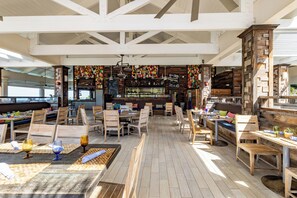 A spacious restaurant with wooden tables and chairs, a bar area, and a view of the city. - Key Largo 3BR Villa | Pool, Kayaks & Resort Perks (Key Largo)