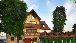 Kaksikerroksinen rakennus, jonka yläpuolella on kyltti, jossa lukee: ”Hotel zur Sonne”.