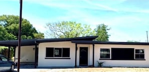 A single-story building with a flat roof, a garage, and a small front yard. - Mid Century Gem Near Theme Parks (Ocoee)